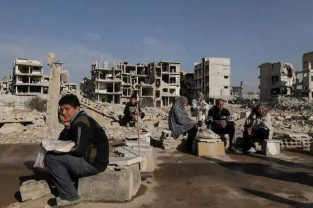 People sit after receiving bread from Ecir Kapici, Turkish humanitarian NGO at Al-Yarmouk Palestinian refugee camp, after Syria's Bashar Al-Assad was ousted, in Damascus, Syria, December 20 , 2024. (Reuters)
