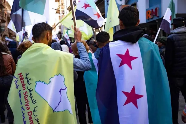 Kurds wave the flags of the SDF and the new Syrian regime during a celebration in the city of Qamishli in northeastern Syria (AFP).
