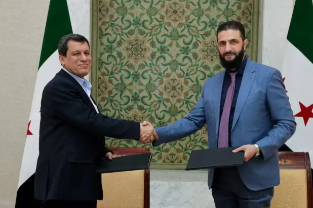 Suriye Devlet Başkanı Ahmed el-Şara ve ABD destekli, Kürt liderliğindeki Suriye Demokratik Güçleri Lideri Mazlum Abdi ile Suriye'nin başkenti Şam'da, 10 Mart 2025'te el sıkışıyor (SANA)