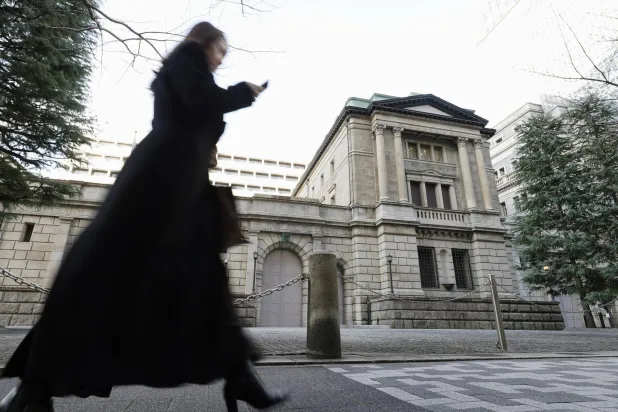سيدة تمر أمام مقر بنك اليابان المركزي في وسط العاصمة طوكيو (أ.ب)