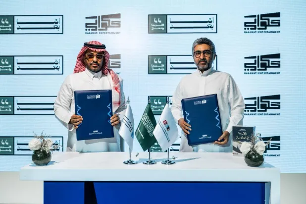 جانب من توقيع الاتفاق لتحويل رواية «القبيلة التي تضحك ليلاً» إلى فيلم (الشرق الأوسط)