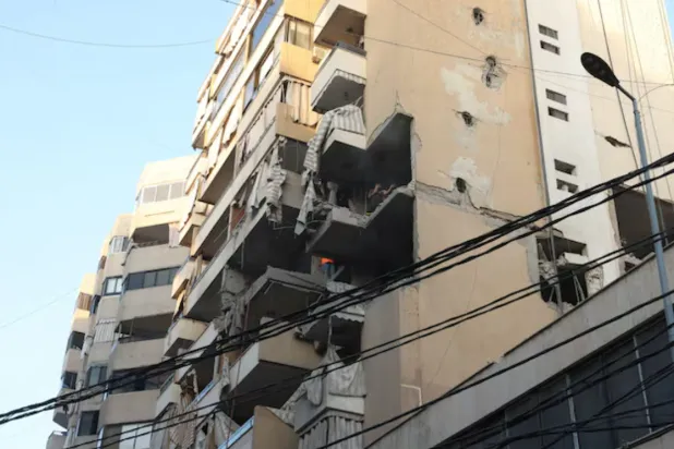 People inspect a damaged building, after Israeli military said on Sunday that it struck a militant from the Lebanese Iran-aligned Hezbollah group, in Beirut's southern suburbs, Lebanon November 23, 2025. REUTERS/Mohamed Azakir 