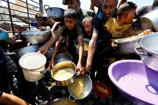 Palestinians wait to receive food from a charity kitchen after the global hunger monitor, in Gaza City, August 28, 2025. REUTERS/Mahmoud Issa/File Photo