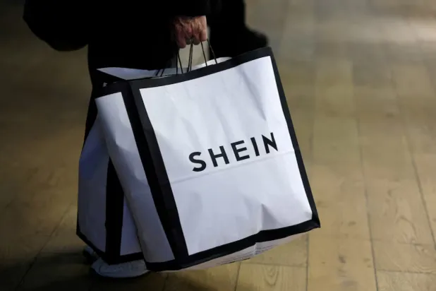 A customer holds shopping bags with a Shein logo in the first physical space of Chinese online fast-fashion retailer Shein on the day of its opening inside the Le BHV Marais department store, the Bazar de l'Hotel de Ville, in Paris, France, November 5, 2025. REUTERS/Sarah Meyssonnier/File Photo 