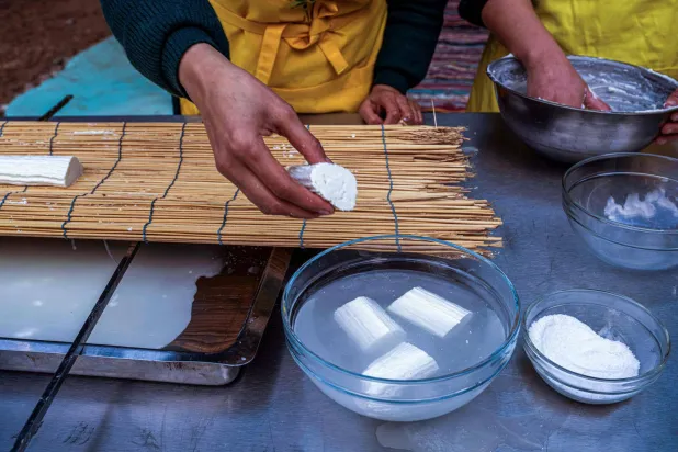 سيدة مصرية تضع قطعاً من جبن القريش المصنع حديثاً (أ.ف.ب)