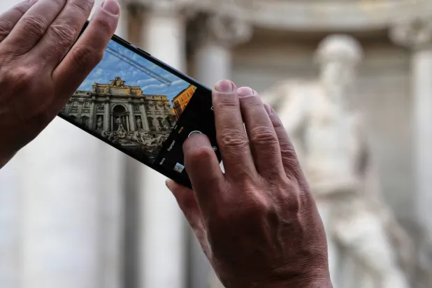  A visitor takes a photo of Rome's Trevi Fountain, Friday, Dec. 19, 2025, as the city municipality announced that, starting on Feb. 1, it will impose a 2 euro fee for tourists to visit the recessed fountain edge. (AP) 
