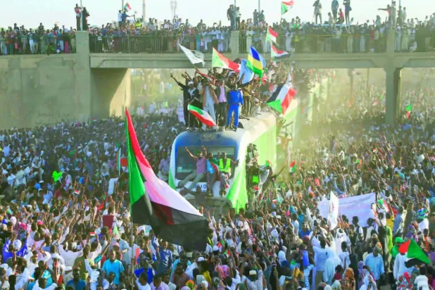 Aralık 2019’da, Atbara kentinden gelen kalabalıklar, başkent Hartum’daki mevkidaşlarıyla birlikte devrim yıl dönümünü kutluyor (AFP)