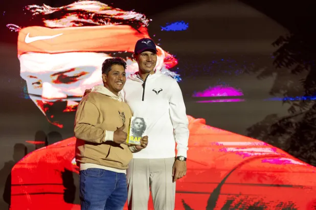 أحد معجبي النجم الإسباني يحمل كتاباً يروي مسيرته (الشرق الأوسط)