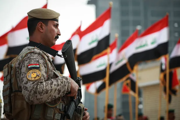ضابط من القوات المسلحة العراقية يقف حارساً خلال عرض عسكري بمناسبة الذكرى الثامنة لانتصار العراق على تنظيم «داعش» (د.ب.أ)