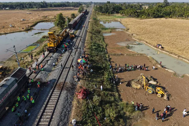 تقوم حفارة بحفر حفرة لدفن جثة فيل بري آسيوي يتم إزالته من على خط سكة حديد بعد أن صدم قطار مسرع قطيعاً من الأفيال البرية (أ.ب)