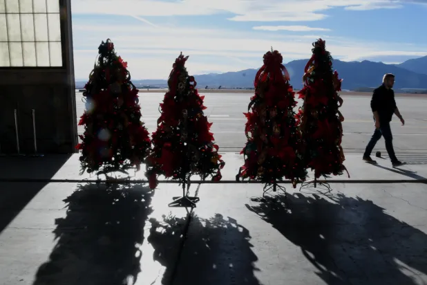 Christmas trees are displayed inside a hangar at Peterson Space Force Base in Colorado Springs, Colo., on Thursday, Dec. 18, 2025 in advance of the annual NORAD Tracks Santa Operation, at the North American Aerospace Defense Command. (AP Photo/Thomas Peipert)
