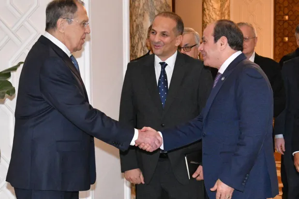 In this photo, provided by Egypt's presidency media office, Egyptian President Abdel-Fattah el-Sisi, front right, greets Russian Foreign Minister Sergei Lavrov, left, before their meeting at the Presidential Palace in Cairo, Egypt, Saturday, Dec. 20, 2025. (Egyptian Presidency Media Office via AP)