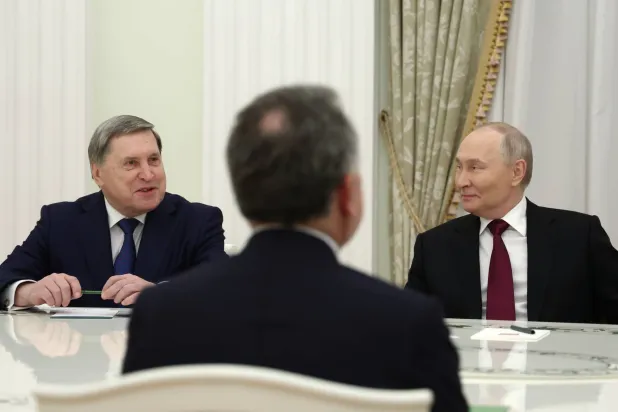 Russian President Vladimir Putin, right, and Russian Presidential foreign policy adviser Yuri Ushakov, left, attend talks with US special envoy Steve Witkoff, back to a camera, at the Senate Palace of the Kremlin in Moscow, Russia, Tuesday, Dec. 2, 2025. (Alexander Kazakov, Sputnik, Kremlin Pool Photo via AP)