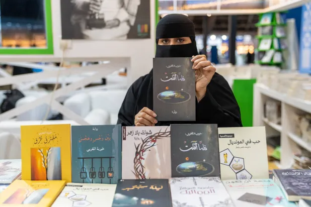 الكاتبة خيرية المغربي مع إصداراتها الأدبية (الشرق الأوسط)