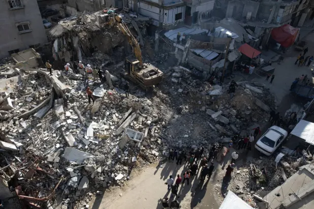 Gazze Şeridi’ndeki Sivil Savunma Müdürlüğü personeli, cumartesi günü Gazze'deki savaş kurbanlarının cesetlerini arama çalışmaları sırasında Han Yunus'taki bir evin enkazını kaldırıyor. (EPA)