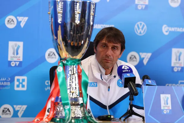 كونتي خلال المؤتمر الصحافي وأمامه كأس السوبر الإيطالي (رويترز)