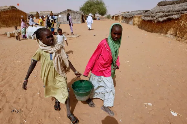 Sudanese refugee girls carry water supplies near a polling station in the refugee camp of Zamzam, on the outskirts of el-Fasher, Darfur, Sudan, on April 13, 2010. (AP) 