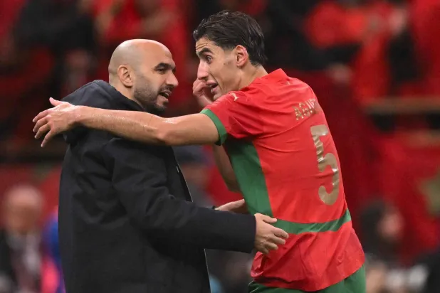 وليد الركراكي مدرب المغرب مع لاعبه نايف أغرد (أ.ف.ب)