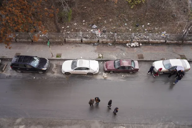 سكان بعض أحياء مدينة حلب يتفقدون سيارات متضررة الثلاثاء عقب موجة هجمات في اليوم السابق (رويترز)