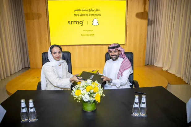 ندى المبارك الرئيسة التنفيذية لـ«SRMG» للحلول الإعلامية وعبد الله الحمادي المدير العام لـ«Snapchat» بالسعودية في أثناء توقيع الاتفاقية (الشرق الأوسط)
