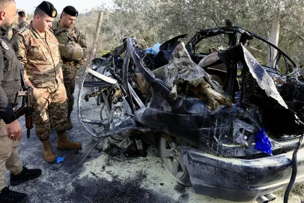 عناصر من الجيش اللبناني يعاينون السيارة التي تم استهدافها في بلدة عتقنيت (قضاء صيدا) وأدت إلى مقتل 3 أشخاص بينهم عنصر بالجيش اللبناني (إ.ب.أ)