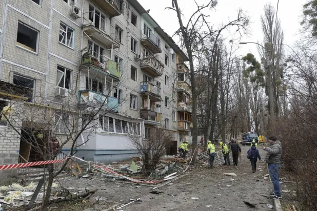 Ukrainian communal workers clean debris at the site of a Russian drone strike on a five-story residential building in Kyiv, Ukraine, 23 December 2025. (EPA) 