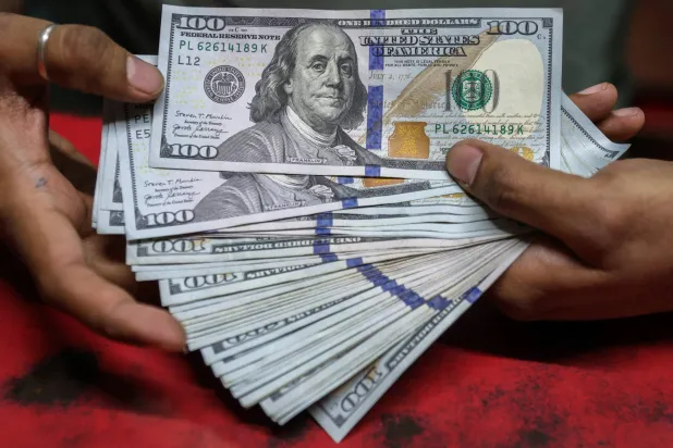 يعرض أحد مكاتب الصرافة في مومباي أوراق نقدية من فئة 100 دولار أميركي (إ.ب.أ)