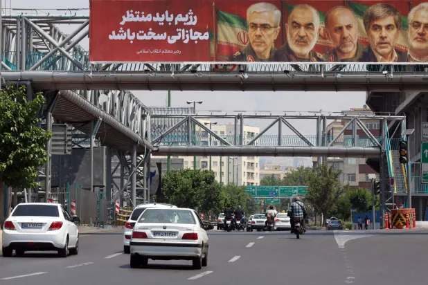 A poster shows slain members of the Iranian Revolutionary Guards Corps, who were killed in the June war, over a highway in Tehran on June 14.