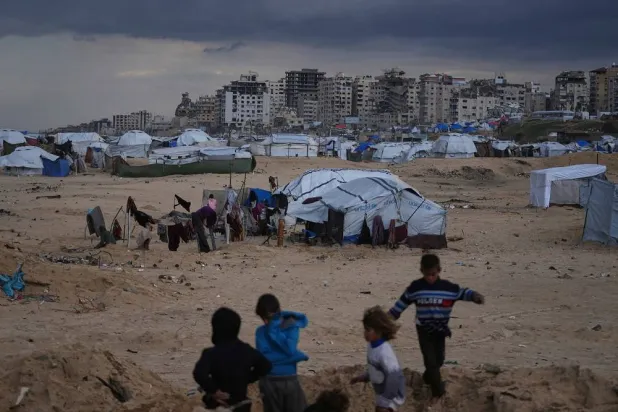 Palestinian children play next to tents in a makeshift camp for displaced people set up on the beach in Gaza City, Tuesday, Dec. 16, 2025. (AP)