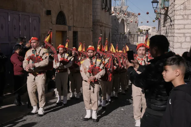  Palestinian scout bands parade toward the Manger Square near the Church of the Nativity, traditionally believed to be the birthplace of Jesus, on Christmas Eve, in the West Bank city of Bethlehem, Wednesday, Dec. 24, 2025. (AP Photo/Mahmoud Illean)

