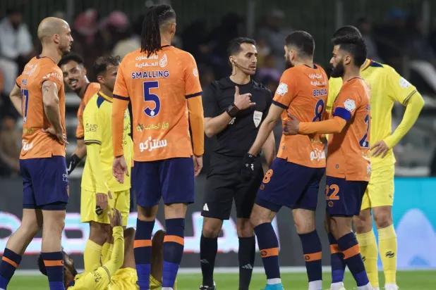 الحكم الزهراني في نقاش مع لاعبي الفريقين بعد إحدى الحالات (تصوير: نايف العتيبي)