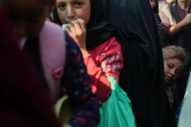 Gazze'nin merkezindeki Deyr el-Belah'ta dün bir yardım kuruluşunun mutfağından yemek almak için bekleyen kuyruklar arasında Filistinli bir kız çocuğu, (AP)