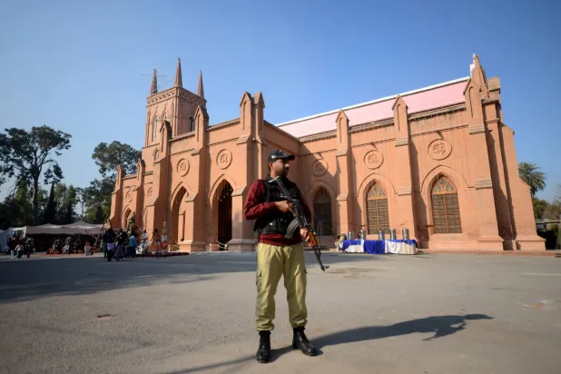 يقف شرطي حارساً خارج كاتدرائية القديس يوحنا المركزية في بيشاور خلال قداس عيد الميلاد (د.ب.أ)