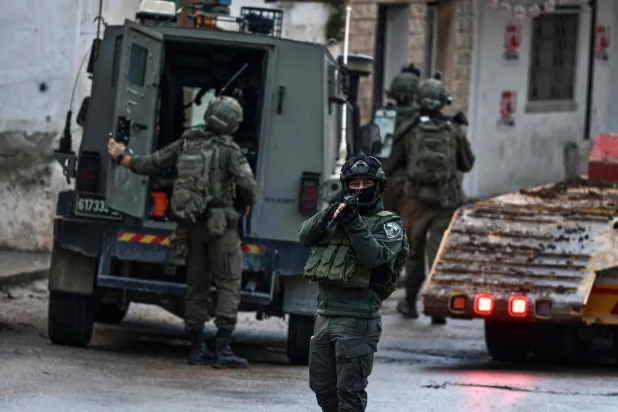 Israeli security forces secure a street as they leave the Palestinian village of Bizariya, in the occupied West Bank, where Israeli authorities demolished the house of a Palestinian man killed in July after he and another man reportedly killed an Israeli settler on the same day, on December 24, 2025. (AFP)