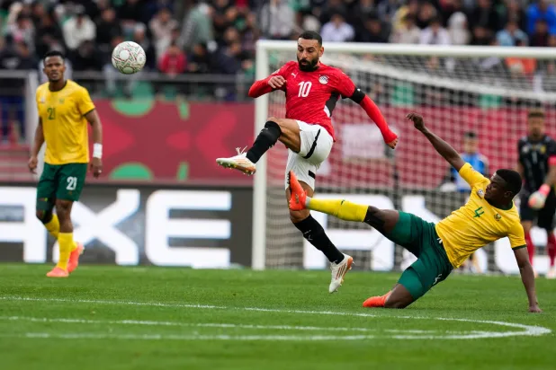 صلاح يسدد الكرة وسط مضايقة موكوينا لاعب جنوب أفريقيا (أ.ب)