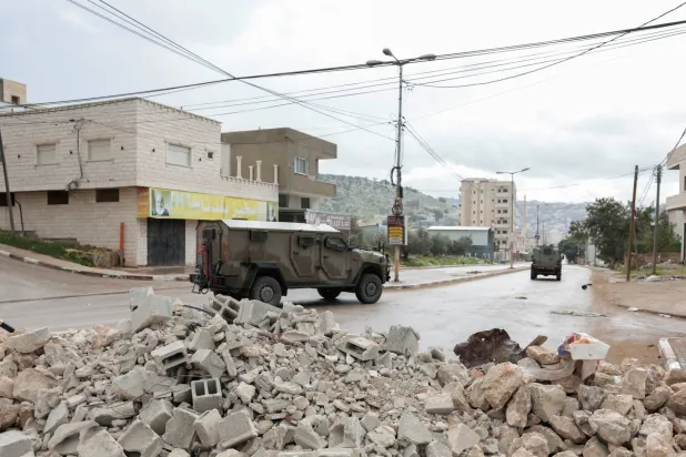 مركبات عسكرية تعمل خلال غارة إسرائيلية على بلدة قباطية قرب جنين (رويترز)