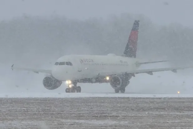 طائرة تستعد للإقلاع خلال عاصفة شتوية في مطار غريتر روتشستر الدولي بنيويورك (رويترز)