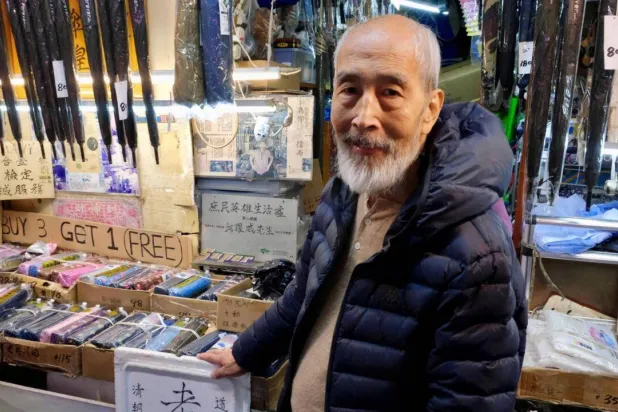 Yau Yiu-wai, 73, one of the few remaining umbrella repairmen in Hong Kong, is closing his 183-year-old family-run business at the end of the year. Tommy WANG / AFP
