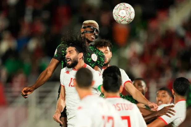 Nigeria's Victor Osimhen, top, wins a header against Tunisia's Ferjani Sassi during the Africa Cup of Nations group C soccer match between Nigeria and Tunisia in Fez, Morocco, Saturday, Dec. 27, 2025. (AP Photo/Mosa'ab Elshamy)