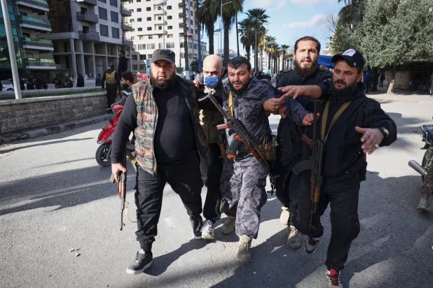 إبعاد ضابط شرطة مصاب عن منطقة الاحتجاجات في اللاذقية (أ.ب)