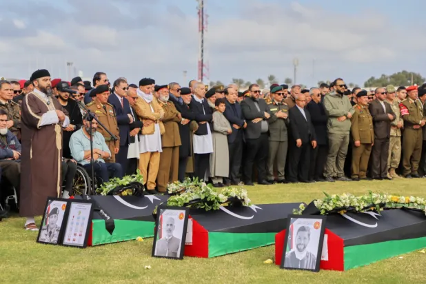 People attend funeral prayers for Gen. Muhammad Ali Ahmad al-Haddad, coffin at left, in Misrata, Libya, Sunday, Dec. 28, 2025, who was killed with others in a plane crash on Tuesday after taking off from Ankara. (AP Photo/Yousef Murad)