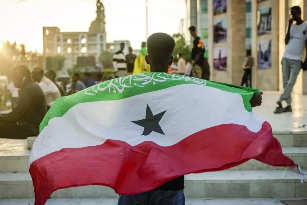 Man holding the Somaliland flag in front of the Hargeisa War memorial (AFP).