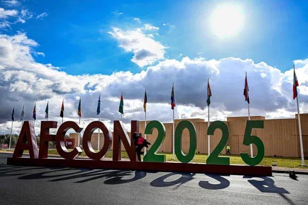 A woman poses for picture in front of AFCON 2025 symbol outside the Fan Zone in Marrakech city on December 25, 2025, during the Africa Cup of Nations (CAN) football tournament. (Photo by Khaled DESOUKI / AFP)