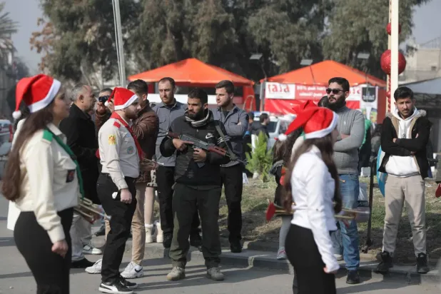 Suriye güvenlik güçleri, Eski Şam'da Hristiyan izcilerin kortejini koruyor. (AFP)