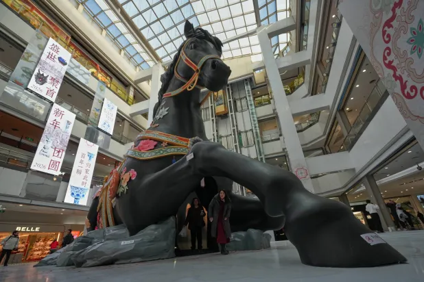 تمثال ضخم في واجهة أحد المراكز التجارية بالعاصمة الصينية بكين ترحيباً بـ«عام الحصان» (أ.ب)