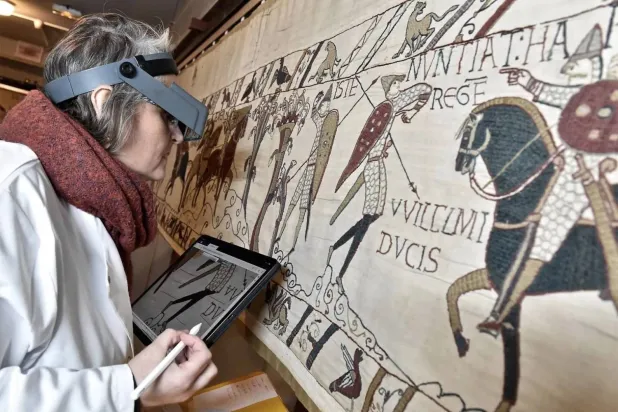 This photo provided by Bayeux townhall shows a technician inspecting the famed Bayeux tapestry in Bayeux, Normandy, in 8th January, 2020. (Ville de Bayeux via AP/File photo)