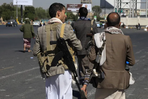 مسلحون حوثيون يسيرون في أحد شوارع العاصمة اليمنية المختطفة صنعاء (إ.ب.أ)