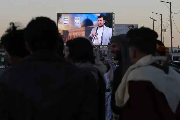 Sana'da Husi liderinin fotoğrafının bulunduğu bir dijital reklam panosunun önünde toplanan insanlar (EPA)