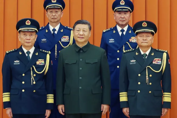  In this photo released by Xinhua News Agency, Chinese President Xi Jinping, also chairman of the Central Military Commission (CMC), front row second from left, poses with other military officers after promoting to generals, back row, from left, Yang Zhibin of the Eastern Theater Command and Han Shengyan commander of Central Theater Command in Beijing on Monday, Dec. 22, 2025. (Li Gang/Xinhua via AP)


