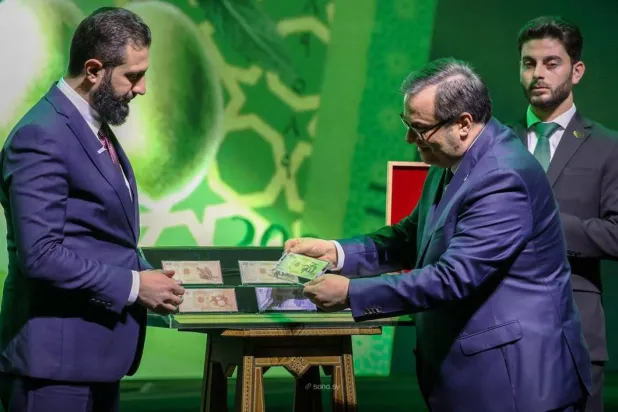 الرئيس السوري وحاكم المصرف المركزي خلال إطلاق العملة الجديدة (سانا)